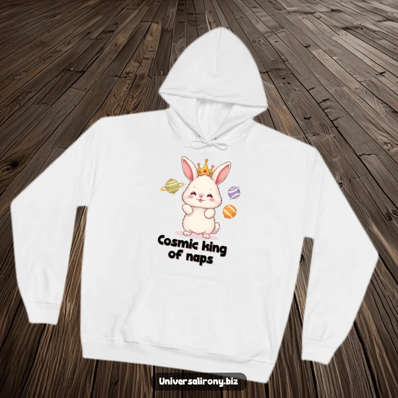 Funny hoodie with a fluffy crowned bunny attempting to hilariously juggle three spinning planets in a whimsical, outer-space-themed design.