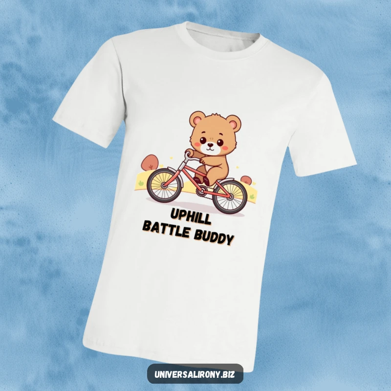 Funny t-shirt with a determined bear cub comically riding a tiny bicycle up a steep hill, showcasing effort and perseverance.